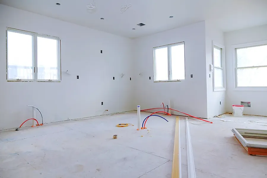 Interior construction of a housing project with drywall installed and first fix electrics.