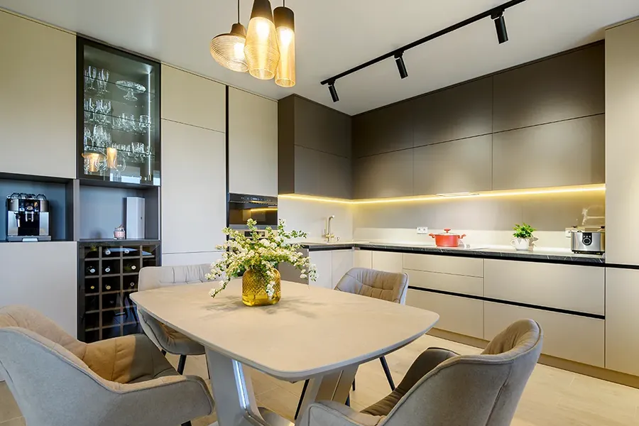 Rewiring a house - A newly installed, large modern grey luxurious kitchen and dining room in studio apartment with under cabinet strip lighting.