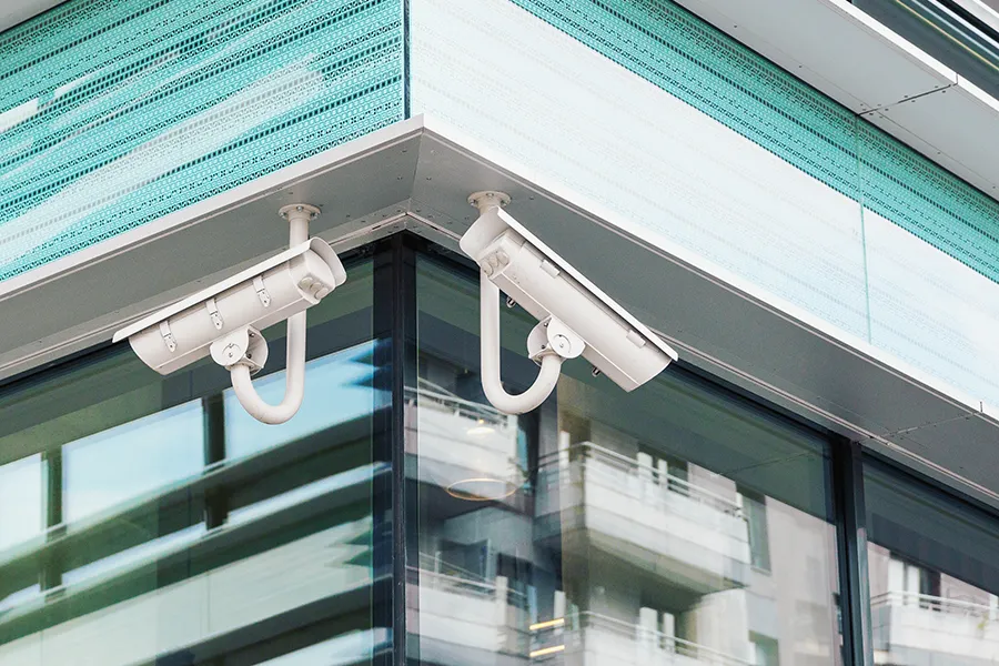 Two modern CCTV security cameras on modern building facade.