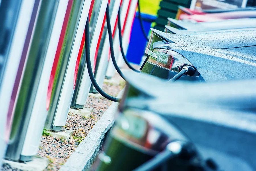 Cars being charged at a row of commercial EV charging points.