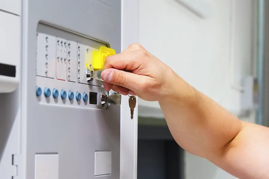 Fire Alarm Maintenance Person checking the fire alarm system using the key on the maintenace panel.