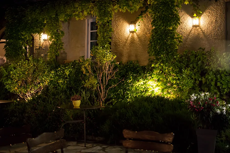 Latern lights installed on a house wall with garden lights illuminating the borders