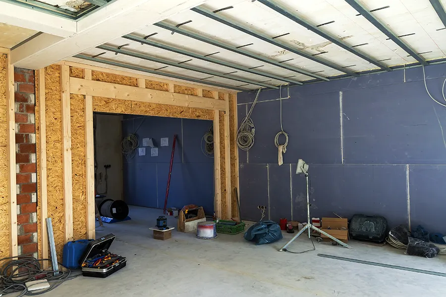Electrical contractors for house extensions & Renovations - The interior of a house under construction with plaster board walls and ceiling support beams, mid way through 1st fix electrics.