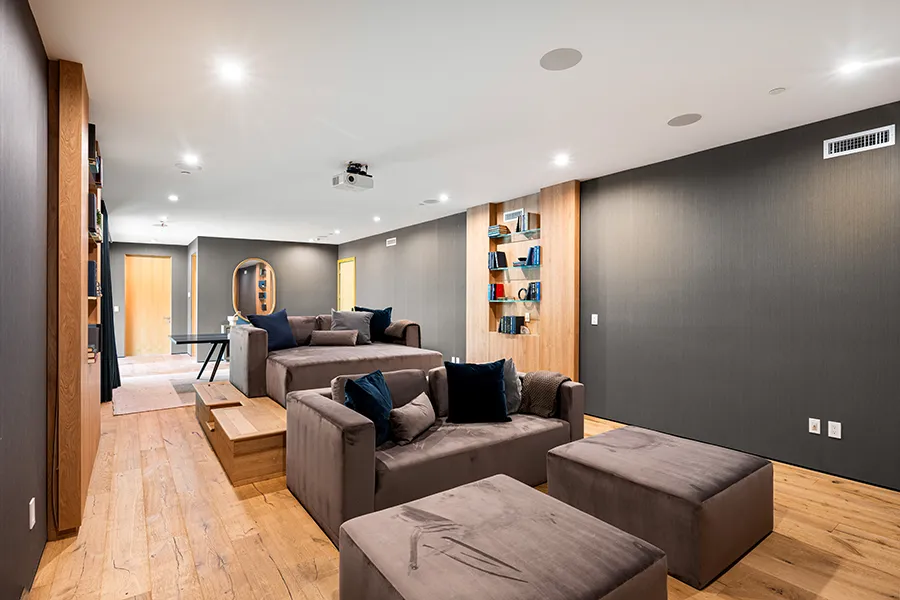 Stylish and cozy smart home cinema with elegant decor and wooden accent.