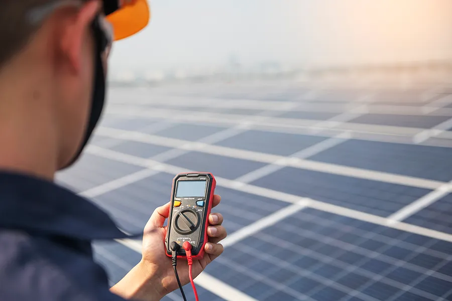 Solar Panel Maintenance Engineer checking the operation of the solar panels on the roof of a building to work at full efficiency.